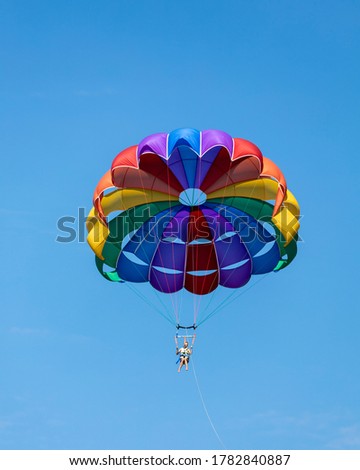 Parasailing, also known as parascending or parakiting, is a recreational kiting activity where a person is towed behind a vehicle (usually a boat) while attached to a specially designed canopy wing