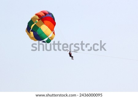 Parasailing, Parascending or Parakiting is an aquatic activity where a person attached to a parachute is towed by a boat at speed, causing them to rise above the water