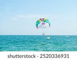 Parasailing in the sea. People have fun with the help of a parachute attraction near the Black Sea coast in Bulgaria. A popular pastime with a parasailing parachute attached to a motorboat