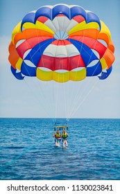 Parasailing water amusement - flying on a parachute behind a boat on a summer holiday by the sea in the resort