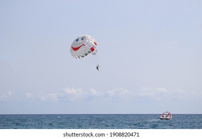 Parasailing water amusement - flying on a parachute behind a boat on a summer holiday by the sea in the resort. Speed boat parasail parachute Parasailing. Tekirova, Antalya Turkey. 27 september, 2020