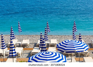 Parasols And Deckchairs On Beach Of Nice In Sunny Summer Day With Blue Sky, Nice, French Riviera, France