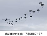 Paratroopers jump from C-130 Hercules military plane on evening