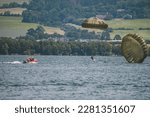 Paratroopers landing on a drop zone. Jumps into the water.