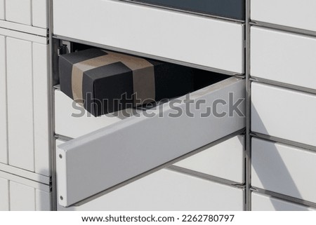 Parcel in the automatic mailbox cabinet. Black parcel in the outbox Close-up.
