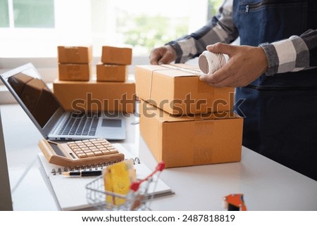 parcel boxes being packaged and ready to be sent to customers who have placed online orders within the online store's system. A small SME businessman has prepared the parcels and is ready for delivery