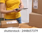 Parcel packing. Post office worker writing notes indoors, closeup