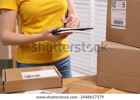 Parcel packing. Post office worker writing notes indoors, closeup