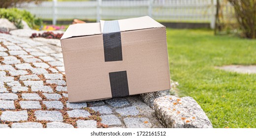 Parcel From Postal Delivery Is Left In The Garden Because The Recipient Is Not At Home.