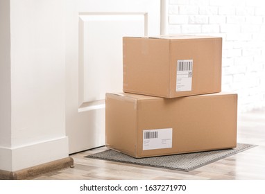 Parcels on rug near door. Delivery service - Shutterstock ID 1637271970