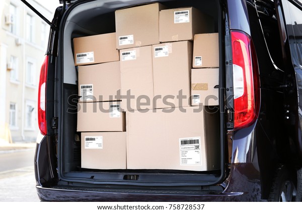 Parcels with\
tracking codes in car trunk\
outdoors