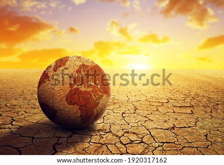 Parched planet earth in the dry landscape with cracked soil at sunset. Global warming or change climate concept. Environmental problems.
