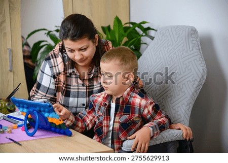 Parent Assists Child Using Educational Device Happily. Mother And Son Engage With Tablet In Cheerful Learning Setting