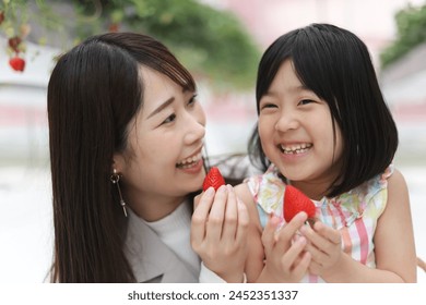 Parent and child enjoying strawberry picking
 - Powered by Shutterstock