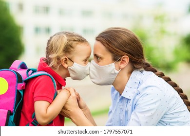 Parent And Child Look Into Each Other's Eyes Before Parting At School And Both Wear Protective Medical Masks On Their Faces Close Up