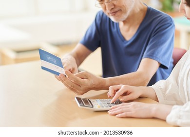 Parent And Child Looking At The Passbook