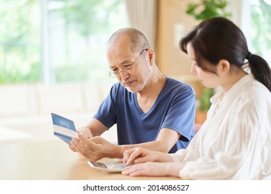 Parent And Child Looking At The Passbook