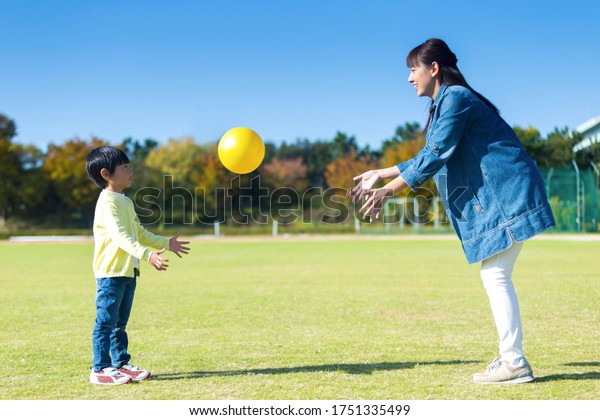 Parent and child\
playing ball in the park