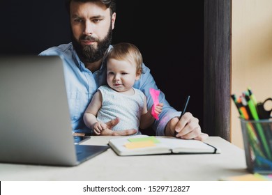 Parent with child studying remotely at homebased laptop. Distant education for people with babies. Young man and toddler sitting in front of laptop. Father with infant watching video lessons, webinars