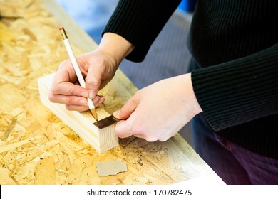 Parent Draws Stencil On Wood Block To Be Used As Body For Pinewood Derby Car