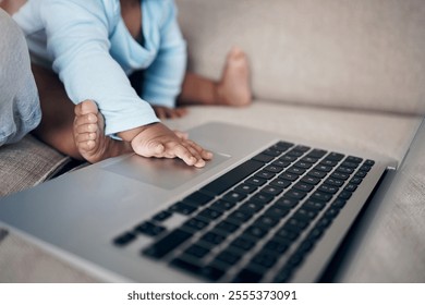 Parent, hands and baby with laptop in home, playing and sensory touch for streaming entertainment. Person, infant feet and relax on couch for cartoon movies, bonding together and internet for film - Powered by Shutterstock