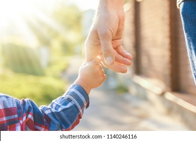 der Elternteil, der die Hand des Kindes hält, auf hellem Hintergrund