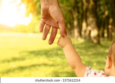the parent holds the hand of a small child