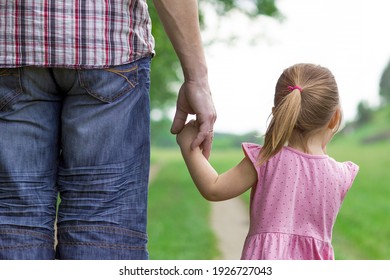 Parent Holds The Hand Of A Small Child And Walk