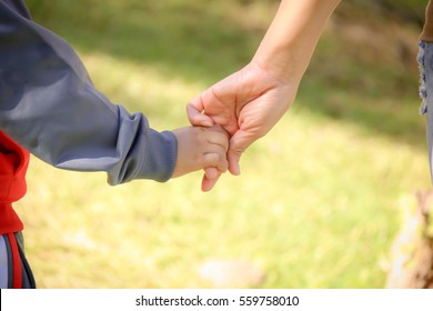 A Parent Holds The Hand Of A Small Child. Love And Bond Between Mother And Child.