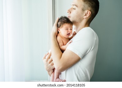 Parent Love, Tenderness Concept. Portrait Of Father And Son Against Light Background, Caucasian White Man Holding His Daughter On Hands. Dad Embracing His Crying Baby With Love And Care, Calming.