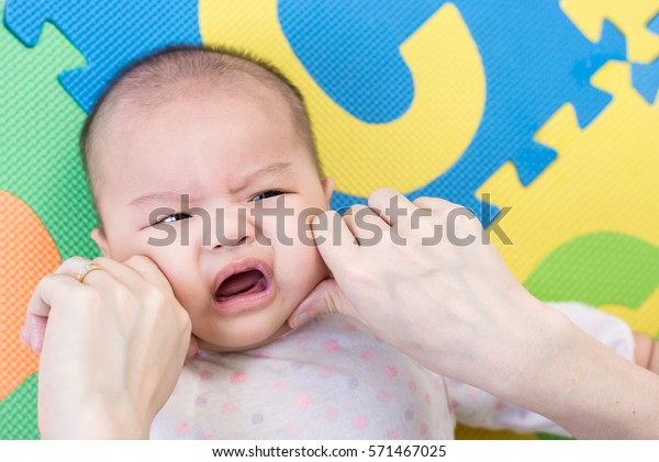 親が頬をつねると カラフルなエバの上に背を乗せ 室内で泡を立てる かわいらしい赤ちゃんの女の子が少し抱き締められる の写真素材 今すぐ編集