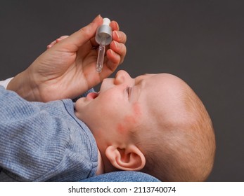 Parent Pipetting Cbd Oil Into Baby's Mouth