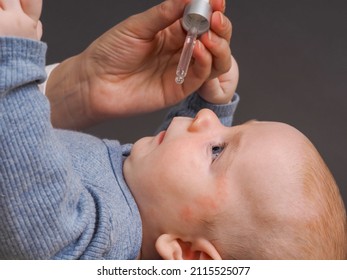 Parent Pipetting Cbd Oil Into Baby's Mouth