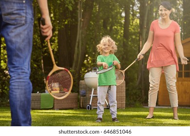 Parent playing badminton with their sweet little son