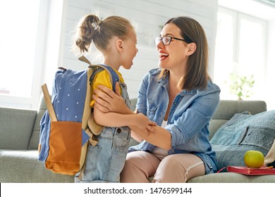 Parent and pupil of preschool. Woman and girl with backpack behind back. Beginning of lessons. First day of fall. - Shutterstock ID 1476599144
