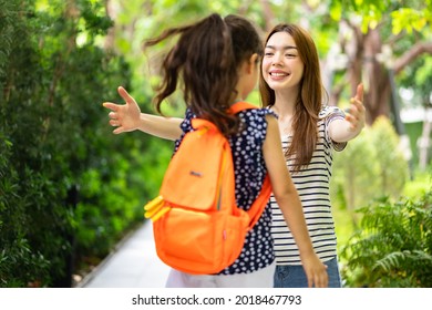 Parent And Pupil Of Primary School Go Hand In Hand. Woman And Kids With Backpack Behind The Back. Beginning Of Lessons.first Day At School.Mother Taking Daughter To School