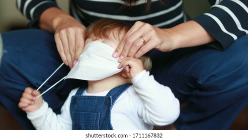 Parent Putting Face Mask To Child Baby. Mother Puts Preventive Surgical Mask Against Outbreak.