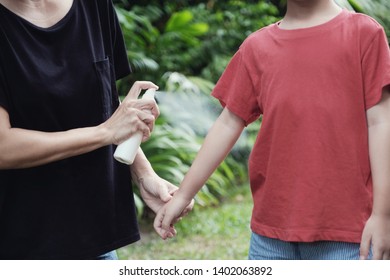 Parent Spraying Insect Bug Repellent On Her Son Skin, Using Mosquito Spray Outdoor