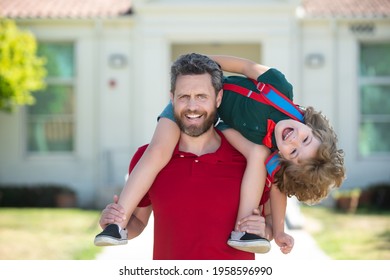 Parent supports and motivates son. Father giving son piggyback ride after come back from school.