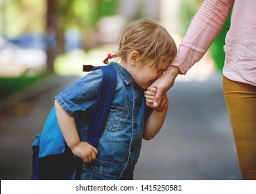 Parent Taking Child To School. Pupil Of Primary School Go Study With Backpack Outdoors. Mom And Daughter Go Hand In Hand. Sad Child Go Back To School. First Day Of Fall. Elementary Student.