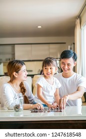 Parent Teaching Their Daughter Saving Money In Piggy Bank