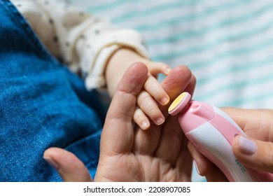 Parent Trimming Baby's Nails With Trimmer