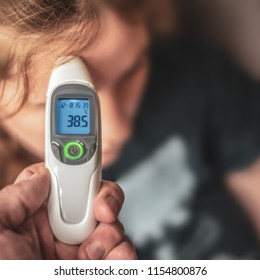 A Parent Using A Digital Thermometer To Take A Child's Temperature