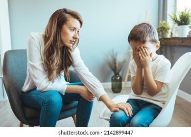 Parenthood and child development, young worried mother comforting little son crying at home. Worried mother comforting crying son. Young boy having therapy with a child psychologist