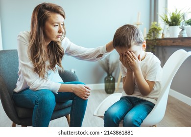 Parenthood and child development, young worried mother comforting little son crying at home. Worried mother comforting crying son. Young boy having therapy with a child psychologist - Powered by Shutterstock