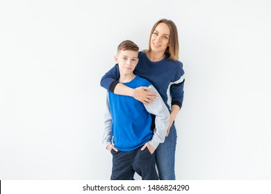 Parenting, Family And Single Parent Concept - A Happy Mother And Teen Son Laughing And Embracing On White Background With Copy Space