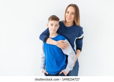 Parenting, Family And Single Parent Concept - A Happy Mother And Teen Son Laughing And Embracing On White Background