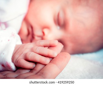 parenting and love concept. Closeup tiny hand the sleeping baby girl in the palm of mother