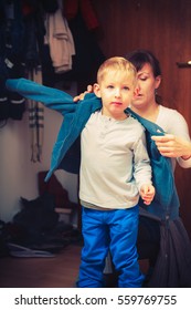 Parenting, Taking Care Of Child Concept. Mother Dressing Up Her Son In Winter Clothes Before Going Out