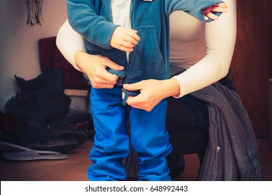 Parenting, Taking Care Of Child Concept. Mother Dressing Up Her Son In Winter Clothes Before Going Out